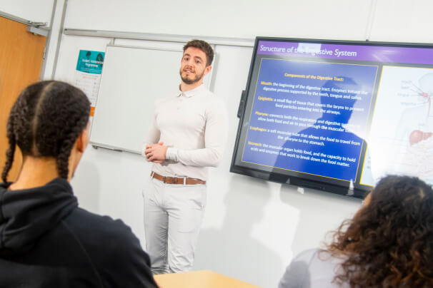 Teacher standing at the front a class of students