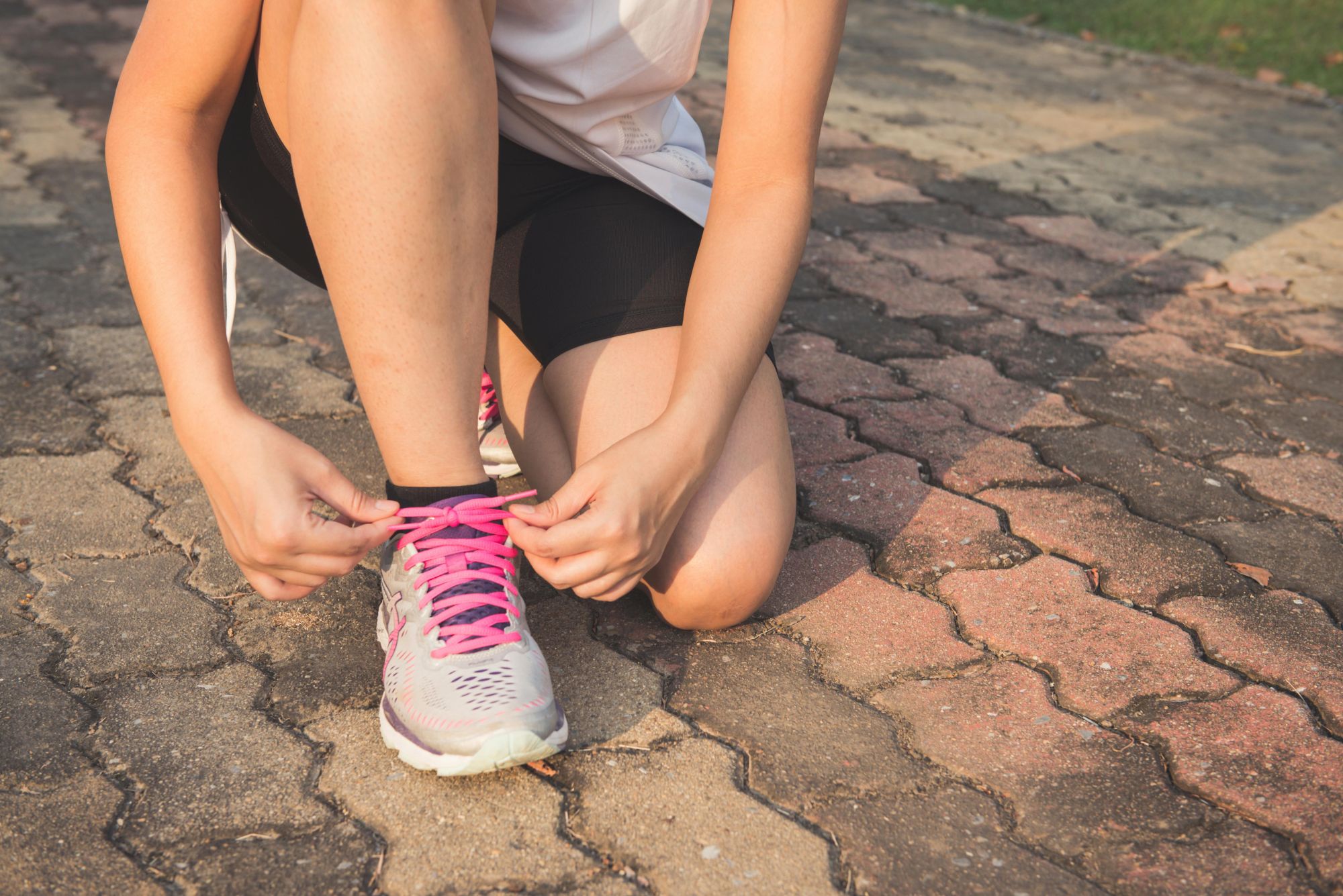 A runner lacing up her shoes